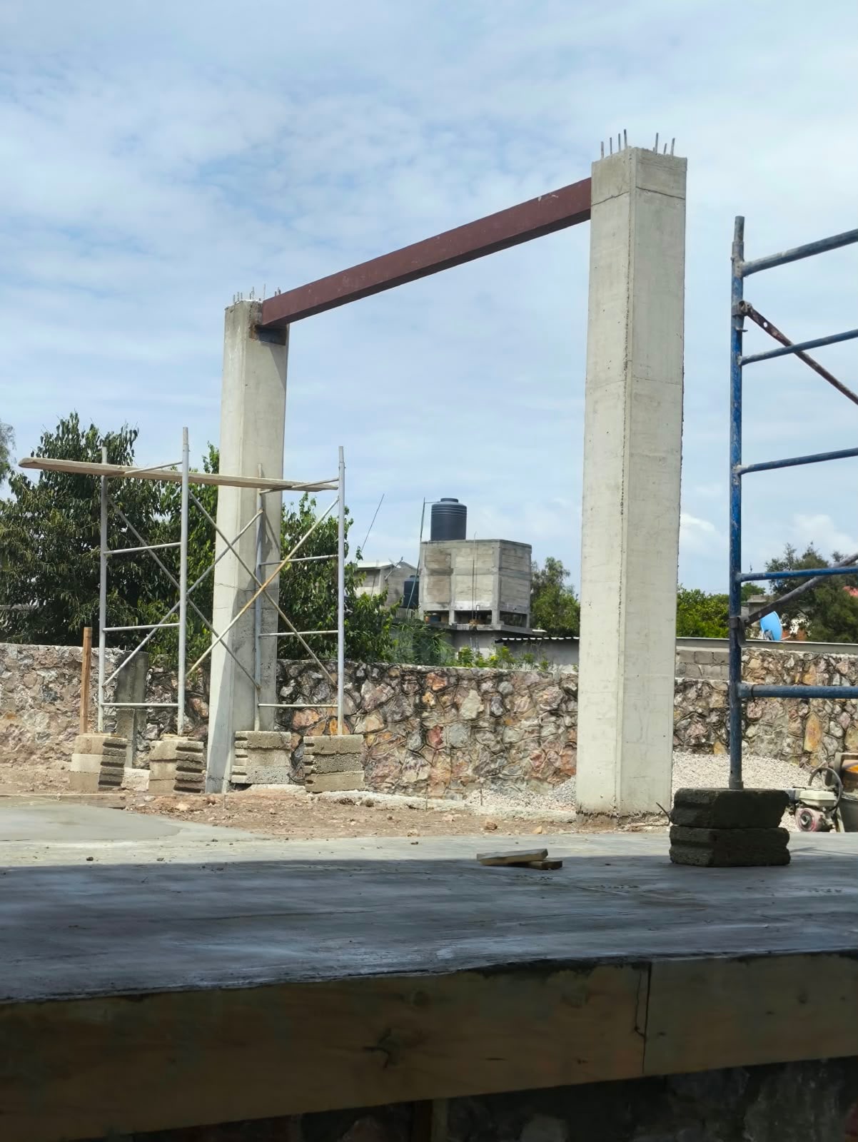 Columnas de concreto unidas por una trabe de acero, con andamios alrededor