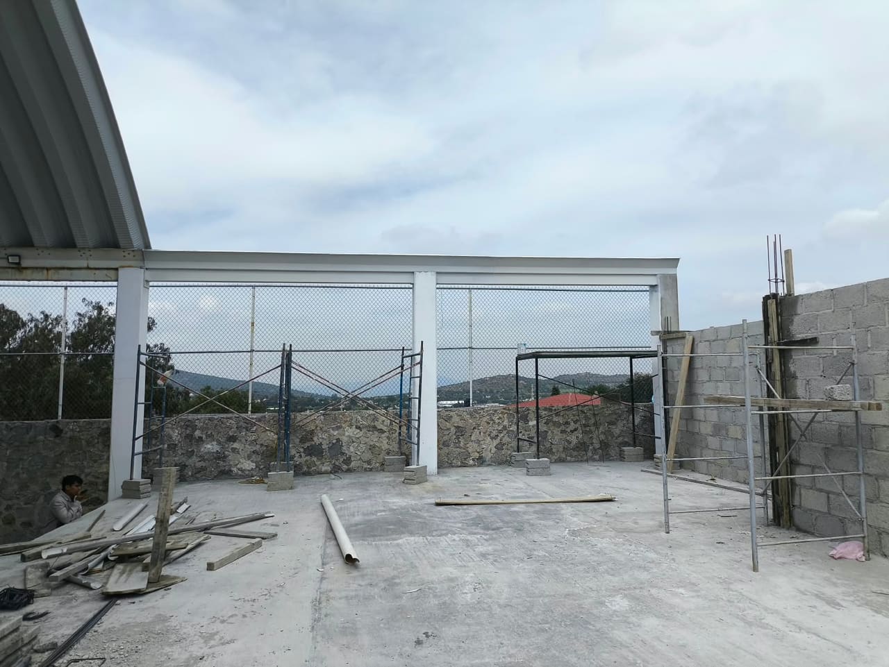 Firme de concreto con columnas, marcos de acero y un muro de block en proceso