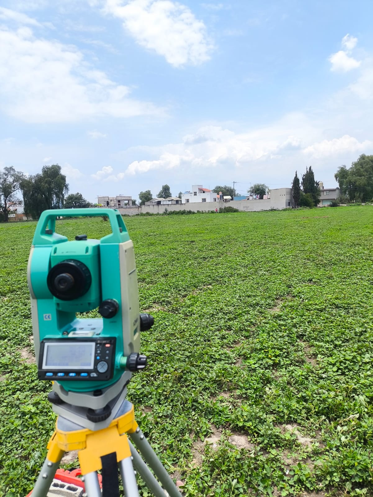 Estación total sobre su tripié en un terreno abierto