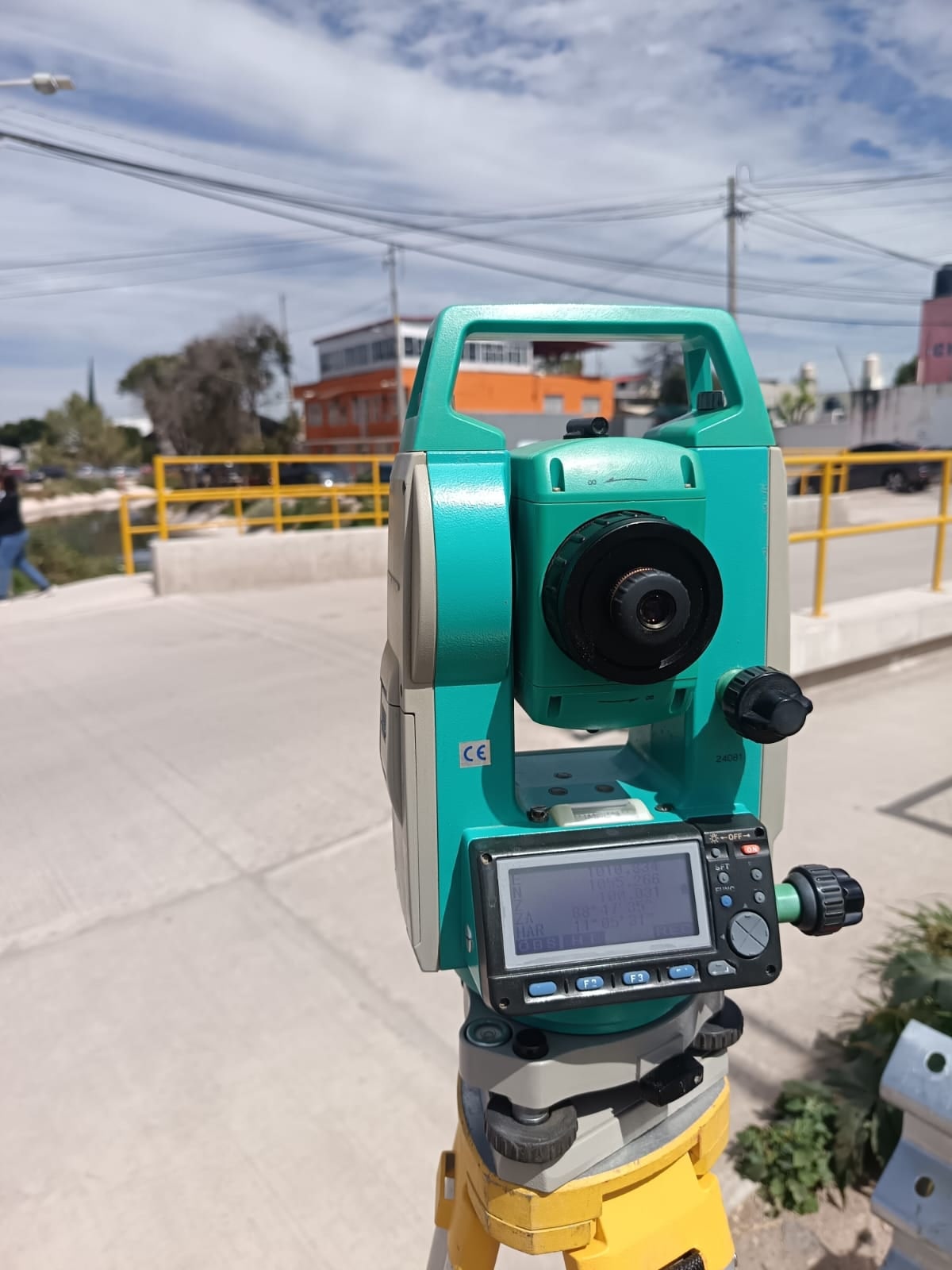 Estación total de cerca, con su pantalla y su lente, durante una medición en la calle